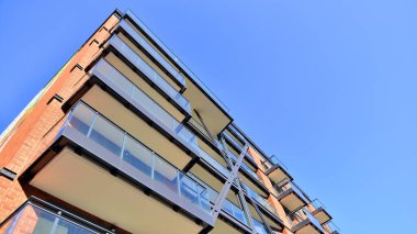 Modern Avrupa apartmanı. Mimarlık ve gayrimenkul, panoramik pencereli bir apartman. Mavi gökyüzü arka planına sahip modern kompleks.