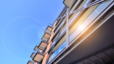 Modern Avrupa apartmanı. Mimarlık ve gayrimenkul, panoramik pencereli bir apartman. Mavi gökyüzü arka planına sahip modern kompleks.