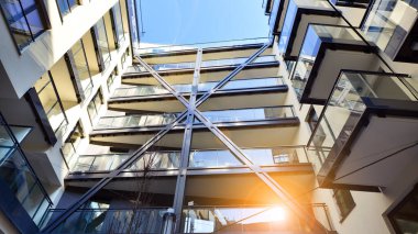 Modern Avrupa apartmanı. Mimarlık ve gayrimenkul, panoramik pencereli bir apartman. Mavi gökyüzü arka planına sahip modern kompleks.