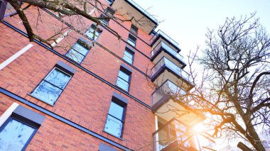 Modern Avrupa apartmanı. Mimarlık ve gayrimenkul, panoramik pencereli bir apartman. Mavi gökyüzü arka planına sahip modern kompleks.