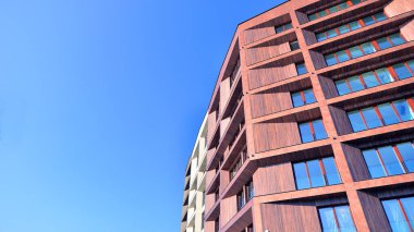 Modern Avrupa apartmanı. Mimarlık ve gayrimenkul, panoramik pencereli bir apartman. Mavi gökyüzü arka planına sahip modern kompleks.