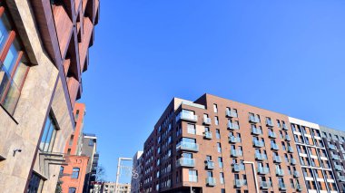 Modern Avrupa apartmanı. Mimarlık ve gayrimenkul, panoramik pencereli bir apartman. Mavi gökyüzü arka planına sahip modern kompleks.