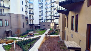 Çok katlı bir apartmanın girişine giden yaya yolu. Yeşil avlusu olan çevre dostu bir bina. Konut kompleksi. Modern apartman.