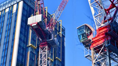 İnşaat alanındaki Crane yüksek binalarla çevrili bir yerde..