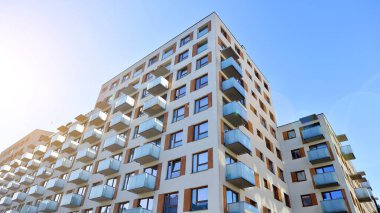 Şehirde simetrik modern mimarisi olan bir apartman. Güneşli bir günde modern apartman binası. Modern bir apartmanın ön cephesi. Alt görünüm. 