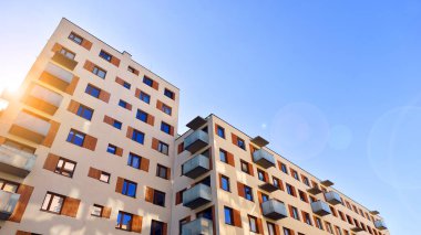 Şehirde simetrik modern mimarisi olan bir apartman. Güneşli bir günde modern apartman binası. Modern bir apartmanın ön cephesi. Alt görünüm. 