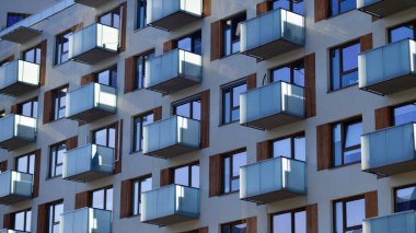 Şehirde simetrik modern mimarisi olan bir apartman. Güneşli bir günde modern apartman binası. Modern bir apartmanın ön cephesi. Alt görünüm. 