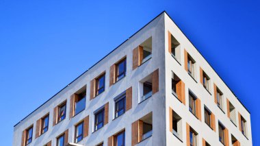 Şehirde simetrik modern mimarisi olan bir apartman. Güneşli bir günde modern apartman binası. Modern bir apartmanın ön cephesi. Alt görünüm. 