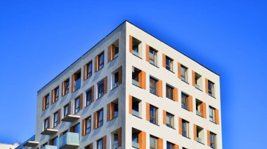 Şehirde simetrik modern mimarisi olan bir apartman. Güneşli bir günde modern apartman binası. Modern bir apartmanın ön cephesi. Alt görünüm. 