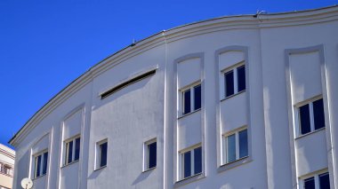 Şehirde simetrik modern mimarisi olan bir apartman. Güneşli bir günde modern apartman binası. Modern bir apartmanın ön cephesi. Alt görünüm. 