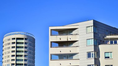 Şehirde simetrik modern mimarisi olan bir apartman. Güneşli bir günde modern apartman binası. Modern bir apartmanın ön cephesi. Alt görünüm. 