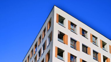 Şehirde simetrik modern mimarisi olan bir apartman. Güneşli bir günde modern apartman binası. Modern bir apartmanın ön cephesi. Alt görünüm. 