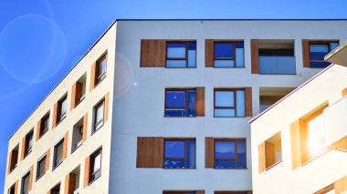 Şehirde simetrik modern mimarisi olan bir apartman. Güneşli bir günde modern apartman binası. Modern bir apartmanın ön cephesi. Alt görünüm. 