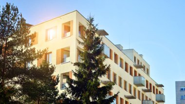 Şehirde simetrik modern mimarisi olan bir apartman. Güneşli bir günde modern apartman binası. Modern bir apartmanın ön cephesi. Alt görünüm. 