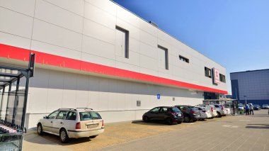 Varşova, Polonya. 6 Mart 2025. Logosu ve markası Kaufland mağazası olan bir tabela. Bir süpermarkete giriş ve müşteri arabaları park halinde..