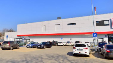 Varşova, Polonya. 6 Mart 2025. Logosu ve markası Kaufland mağazası olan bir tabela. Bir süpermarkete giriş ve müşteri arabaları park halinde..