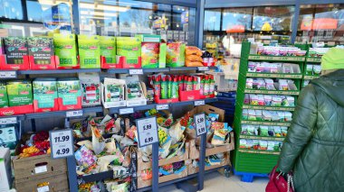 Varşova, Polonya. 6 Mart 2025. Gazeteler, bahçe malzemeleri, tanıtım afişleri ve kapılarla Lidl süpermarket giriş alanı.