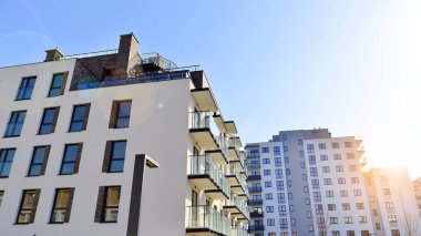 Şehirde simetrik modern mimarisi olan bir apartman. Güneşli bir günde modern apartman binası. Modern bir apartmanın ön cephesi. Alt görünüm. 