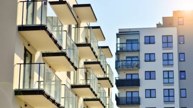 Şehirde simetrik modern mimarisi olan bir apartman. Güneşli bir günde modern apartman binası. Modern bir apartmanın ön cephesi. Alt görünüm. 