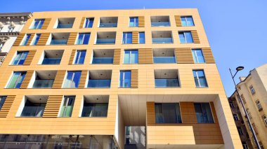 Cam balkonlu yeni apartman. Deniz kenarındaki modern mimari evler. Binanın ön cephesinde büyük camlar var..