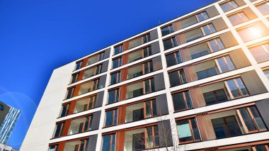 Cam balkonlu yeni apartman. Deniz kenarındaki modern mimari evler. Binanın ön cephesinde büyük camlar var..