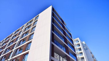 Cam balkonlu yeni apartman. Deniz kenarındaki modern mimari evler. Binanın ön cephesinde büyük camlar var..