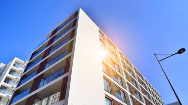 Cam balkonlu yeni apartman. Deniz kenarındaki modern mimari evler. Binanın ön cephesinde büyük camlar var..