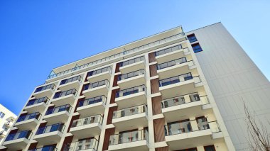 Cam balkonlu yeni apartman. Deniz kenarındaki modern mimari evler. Binanın ön cephesinde büyük camlar var..