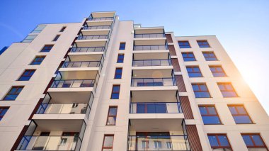 Cam balkonlu yeni apartman. Deniz kenarındaki modern mimari evler. Binanın ön cephesinde büyük camlar var..