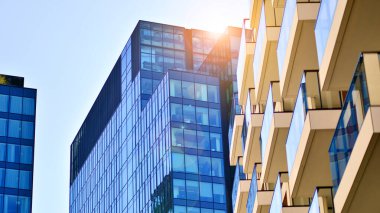 Yeni modern ofis binasının yanında camdan yüzlü modern bir apartman manzarası..