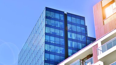 Yeni modern ofis binasının yanında camdan yüzlü modern bir apartman manzarası..