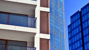 Yeni modern ofis binasının yanında camdan yüzlü modern bir apartman manzarası..