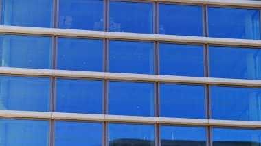 Şehir merkezindeki işletme bölgesi mimarisi. Mavi gökyüzüne ve güneş ışığına karşı cam yansıtıcı ofis binaları. Ekonomi, finans, iş faaliyeti konsepti. Ufukta yükselen güneş.