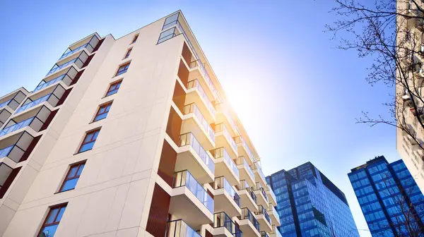 Yeni modern ofis binasının yanında camdan yüzlü modern bir apartman manzarası..