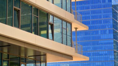 Şehir merkezindeki işletme bölgesi mimarisi. Mavi gökyüzüne ve güneş ışığına karşı cam yansıtıcı ofis binaları. Ekonomi, finans, iş faaliyeti konsepti. Ufukta yükselen güneş.