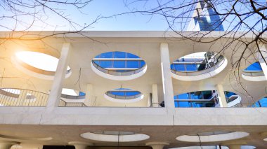 Şehir merkezindeki işletme bölgesi mimarisi. Mavi gökyüzüne ve güneş ışığına karşı cam yansıtıcı ofis binaları. Ekonomi, finans, iş faaliyeti konsepti. Ufukta yükselen güneş.