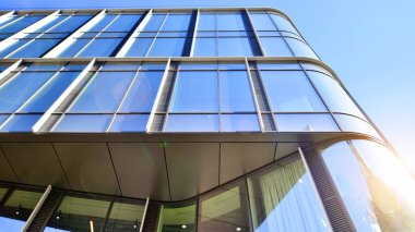 Gökyüzü arka planında cam cepheli modern ofis binası. Ofis binasının şeffaf cam duvarı.