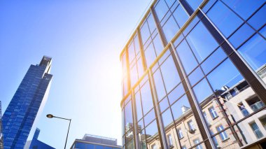 Gökyüzü arka planında cam cepheli modern ofis binası. Ofis binasının şeffaf cam duvarı.