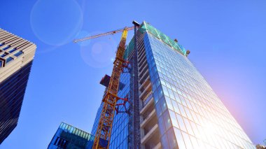 Yüksek bina yapım aşamasında. Güçlendirilmiş beton yapı üzerine cam ön panel kurulumu.