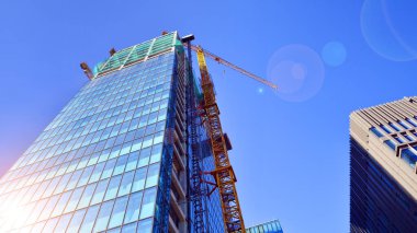Yüksek bina yapım aşamasında. Güçlendirilmiş beton yapı üzerine cam ön panel kurulumu.