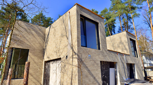 Пригородный район односемейных домов. Строительная площадка под индивидуальный жилой дом. Современный спроектированный односемейный дом в стадии строительства.