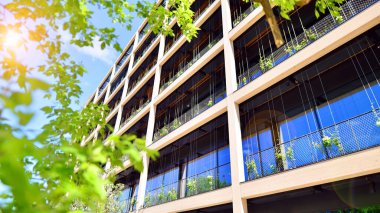 Ağaçlı modern şehir ekonomi bürosu binası. Modern mimari cephesinin detaylı görüntüleri, iş kavramları. Çevre. Modern bina ve ağaçlar, çift pozlama.