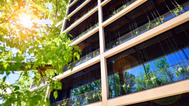 Ağaçlı modern şehir ekonomi bürosu binası. Modern mimari cephesinin detaylı görüntüleri, iş kavramları. Çevre. Modern bina ve ağaçlar, çift pozlama.