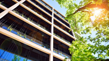 Ağaçlı modern şehir ekonomi bürosu binası. Modern mimari cephesinin detaylı görüntüleri, iş kavramları. Çevre. Modern bina ve ağaçlar, çift pozlama.