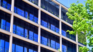 Ağaçlı modern şehir ekonomi bürosu binası. Modern mimari cephesinin detaylı görüntüleri, iş kavramları. Çevre. Modern bina ve ağaçlar, çift pozlama.