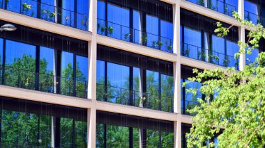 Ağaçlı modern şehir ekonomi bürosu binası. Modern mimari cephesinin detaylı görüntüleri, iş kavramları. Çevre. Modern bina ve ağaçlar, çift pozlama.