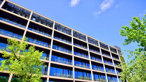 Ağaçlı modern şehir ekonomi bürosu binası. Modern mimari cephesinin detaylı görüntüleri, iş kavramları. Çevre. Modern bina ve ağaçlar, çift pozlama.