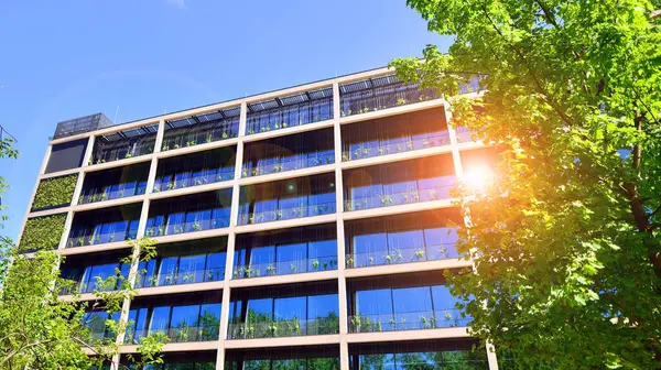 Ağaçlı modern şehir ekonomi bürosu binası. Modern mimari cephesinin detaylı görüntüleri, iş kavramları. Çevre. Modern bina ve ağaçlar, çift pozlama.