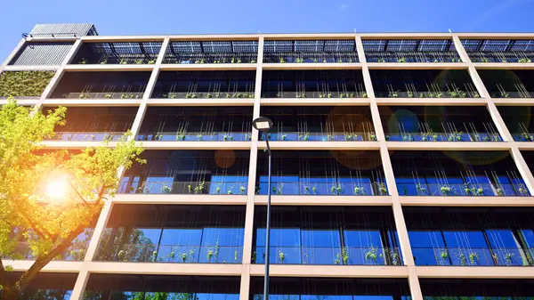 Ağaçlı modern şehir ekonomi bürosu binası. Modern mimari cephesinin detaylı görüntüleri, iş kavramları. Çevre. Modern bina ve ağaçlar, çift pozlama.