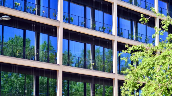 Ağaçlı modern şehir ekonomi bürosu binası. Modern mimari cephesinin detaylı görüntüleri, iş kavramları. Çevre. Modern bina ve ağaçlar, çift pozlama.
